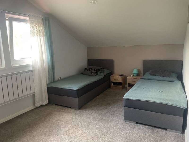 Dvoulůžkový pokoj v rodinném domě s kobercem a střešním oknem.