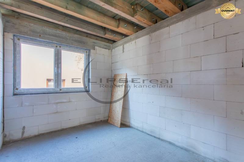 Budova s bílými stěnami a velkým okenním otvorem.