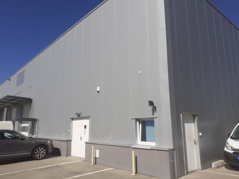 Sklady a haly na Technické ulici v Bratislavě-Ružinově, s zaparkovanými auty před vstupem.