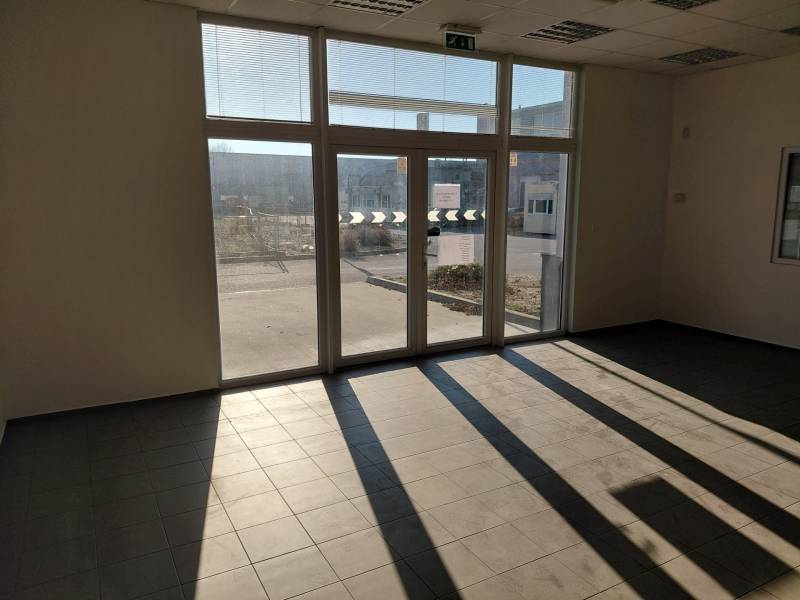 Prostorný interiér s velkými okny a dlažbou ve skladech a halách.