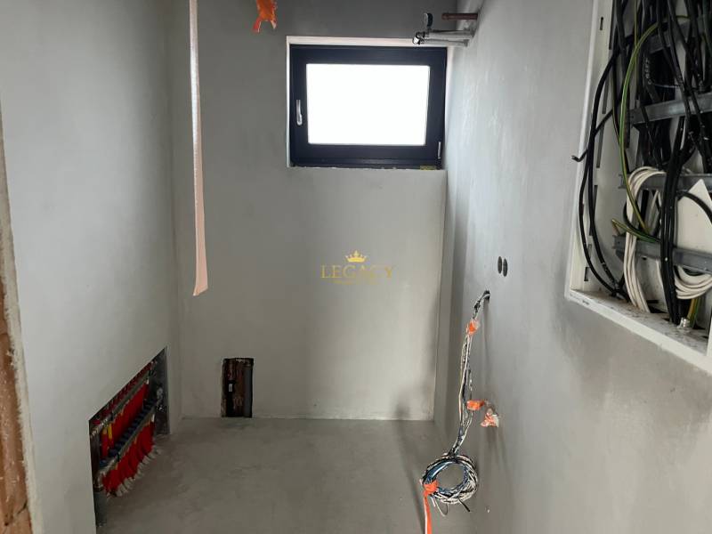 Pokoj v rodinném domě s rozvody a malým oknem, probíhá proces rekonstrukce.