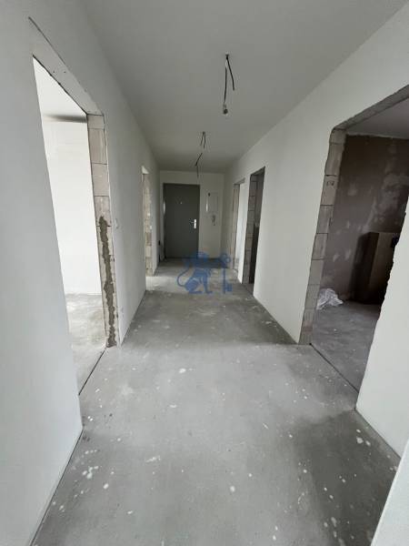 Chodba v 3-pokojovém bytě s nedokončenou omítkou a podlahovou úpravou.