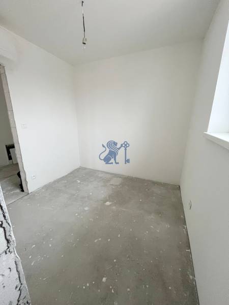 Nepřiřazený pokoj v 3-pokojovém bytě s bílými stěnami a nedokončenou podlahou.