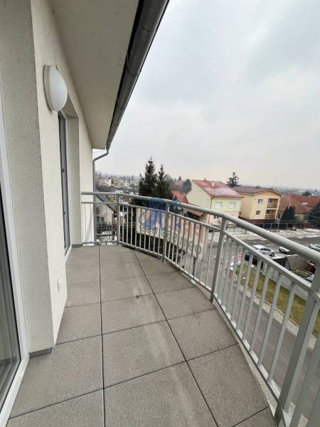 Balkon s dlážděnou podlahou a výhledem na ulici Školskou v Chorvátském Grobu.