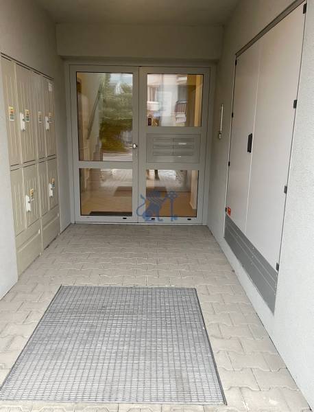 Vchod do bytového domu na Školské ulici v Chorvatském Grobu, s uzamykatelnými schránkami.