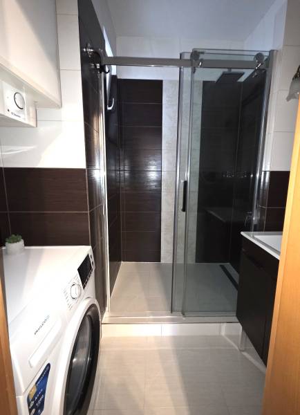 Koupelna v 3-pokojovém bytě se sprchovým koutem a pračkou.