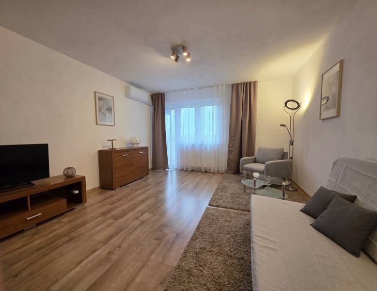 Obývací pokoj v 3-pokojovém bytě s podlahou s dřevěným dekorem a pohodlným nábytkem.