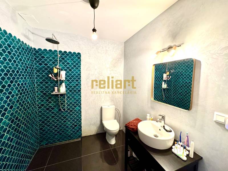 Koupelna s tmavou podlahou a modrými obklady v rodinném domě.