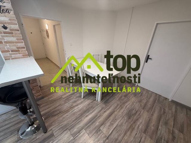 1-pokojový byt s podlahou s dřevěným dekorem a jídelním stolem.