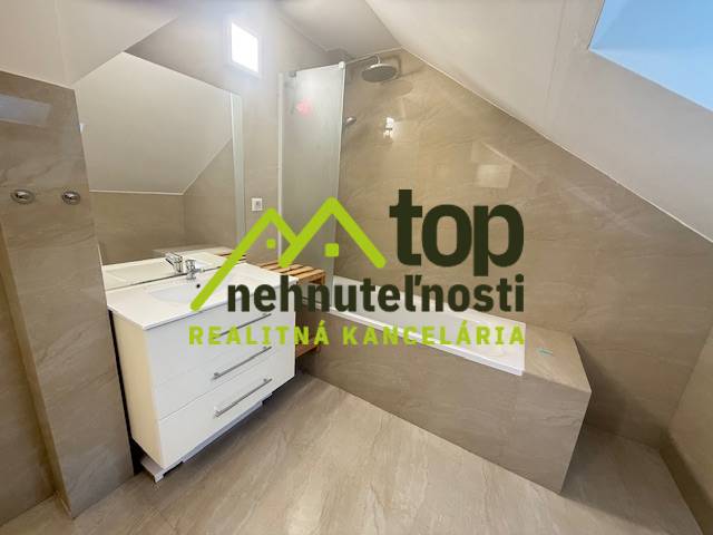 Koupelna v 1-pokojovém bytě se sprchovým koutem a umyvadlem.