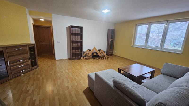 Velký obývací pokoj v 3-pokojovém bytě s pohodlnou sedačkou a dřevěným dekorem.