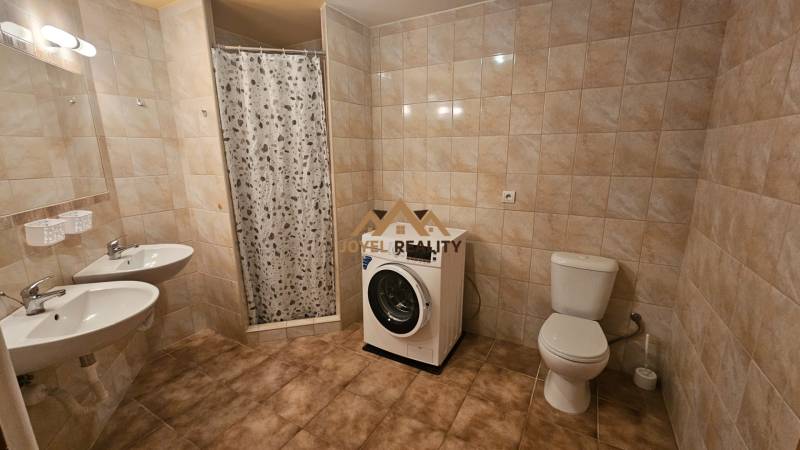 Koupelna v 3pokojovém bytě se sprchou, dvojitým umyvadlem, toaletou a pračkou.