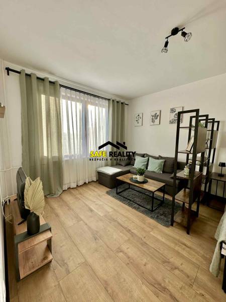 Interiér 1-pokojového bytu s pohovkou, stolkem a podlahou s dřevěným dekorem.