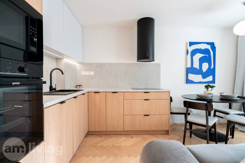 Kuchyně s podlahou s dřevěným dekorem, dřevěnými skříňkami a jídelním stolem ve 3-pokojovém bytě.