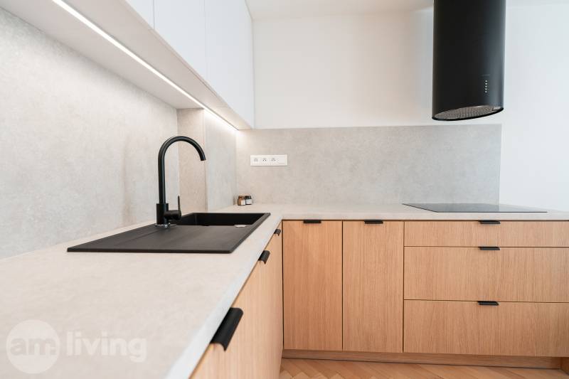 Kuchyňská linka v 3-pokojovém bytě s podlahou s dřevěným dekorem a černým dřezem.