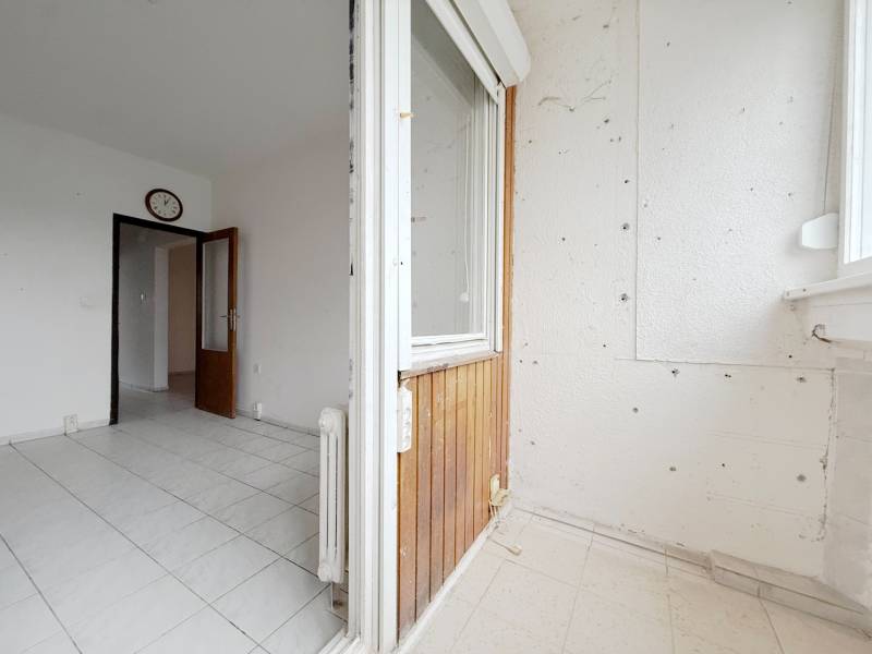 Balkon s dlažbou ve 4-pokojovém bytě, pohled do předsíně s dveřmi.