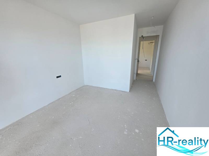 Rekreační apartmán s bílými stěnami a základní podlahou bez dekoru.