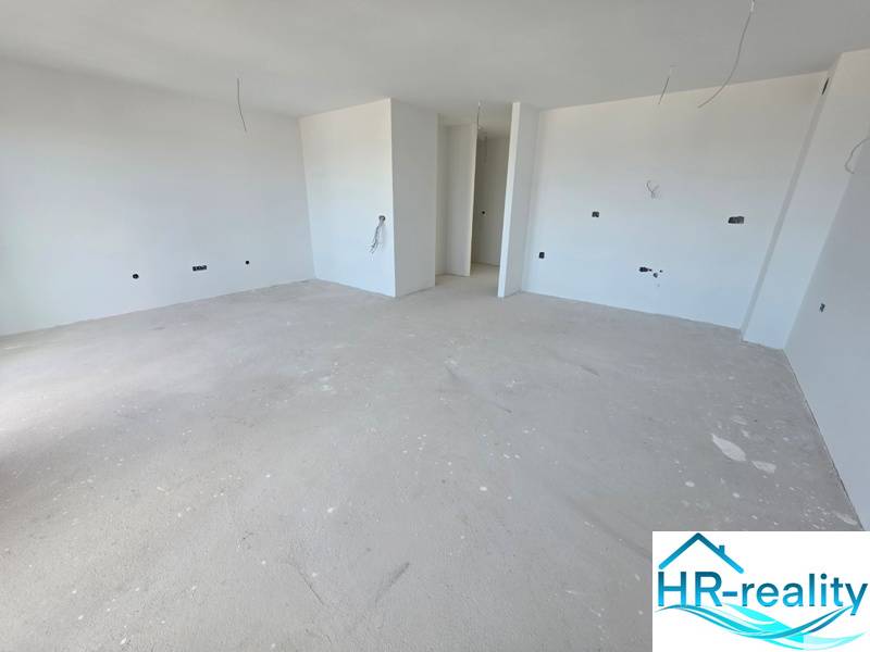 Obývací prostor Rekreačního apartmánu s bílými stěnami ve výstavbě.