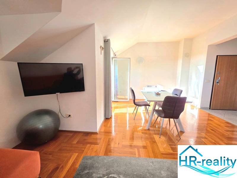 Interiér rekreačního apartmánu s podlahou s dřevěným dekorem a jídelním stolem.