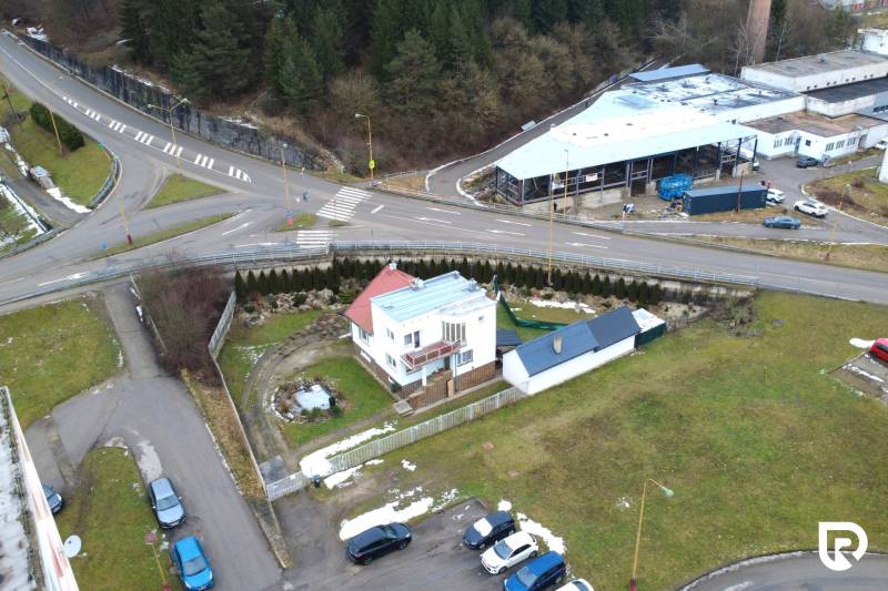 Rodinný dům na ulici SNP v Považské Bystrici, obklopený zelenými plochami a křižovatkou.