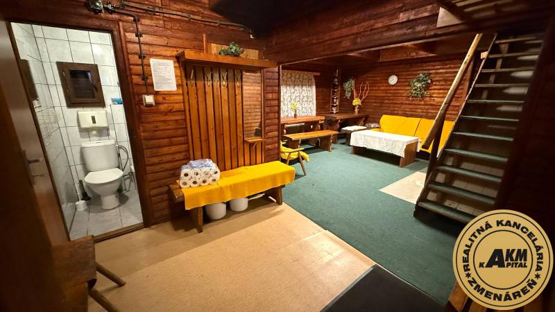 Interiér chaty s dřevěnými stěnami a zařízením, pohodlné sezení, toaleta.