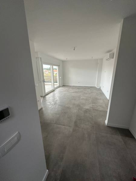 Obývací pokoj v 3-pokojovém bytě s terasou a šedou dlažbou.