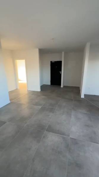 Interiér 3-pokojového bytu s velkými dlaždicemi a bílými stěnami.