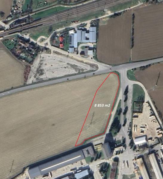 Letecký pohled na komerční pozemky v Trenčianských Bohuslavicích, ohraničené červenou čarou.