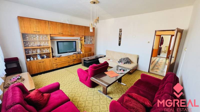 Obývací pokoj v rodinném domě s retro nábytkem a barevnými křesly.