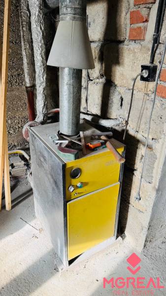 Kotle v rodinném domě, s nářadím nahoře, v nedokončené místnosti.