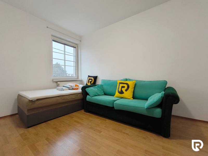 Pokoj s pohovkou a postelí, podlaha s dřevěným dekorem, rodinný dům.