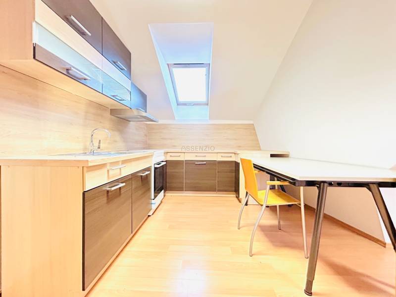 Kanceláře s kuchyní a jídelním stolem, světlá podlaha s dřevěným dekorem.