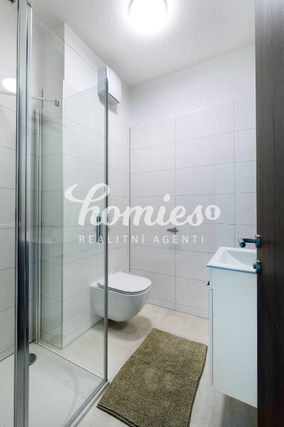 Koupelna ve 3-pokojovém bytě s toaletou, sprchovým koutem a umyvadlem.