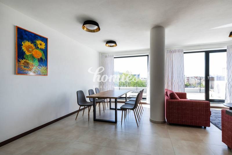 Jídelna ve 3-pokojovém bytě s obrazem slunečnic, podlahou s dřevěným dekorem, výhledem na terasu.