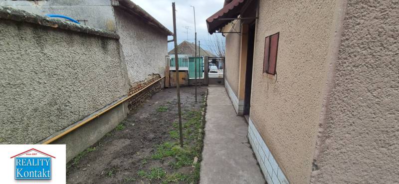 Úzký dvůr rodinného domu v Dvorech nad Žitavou se zahradním prostorem.