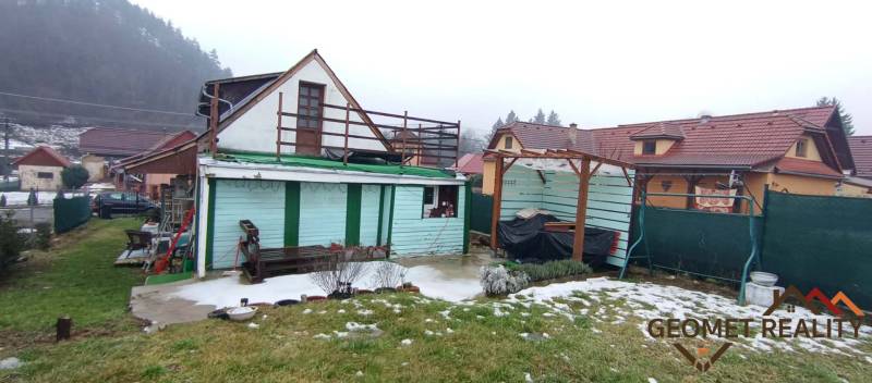 Rodinný dům na Cintorínské v Divíně s přístřeškem na dvoře a zasněženým trávníkem.