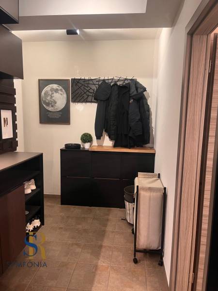 Předsíň v 2-pokojovém bytě s praktickým nábytkem a dekorací měsíce na stěně.