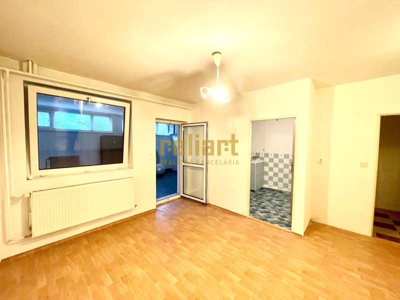 Interiér rodinného domu s podlahou s dřevěným dekorem, výhledem na pokoj a koupelnu.