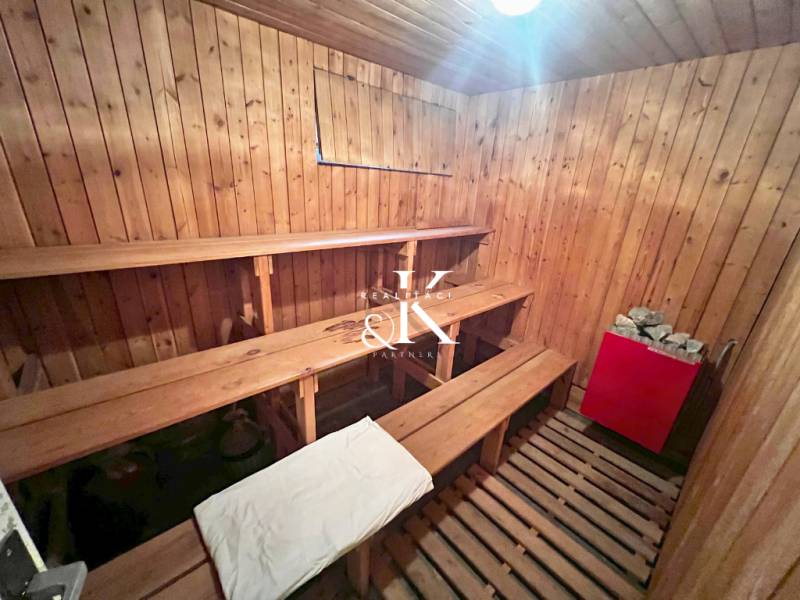 Dřevěná sauna s lavicemi a kamny v chatě.