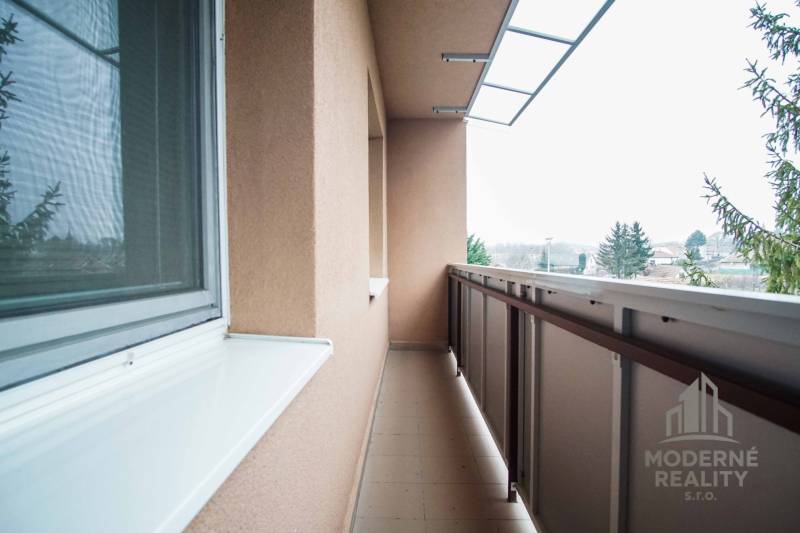 Balkón 4-pokojového bytu v Kolte s výhledem na zeleň a místní scenérii.