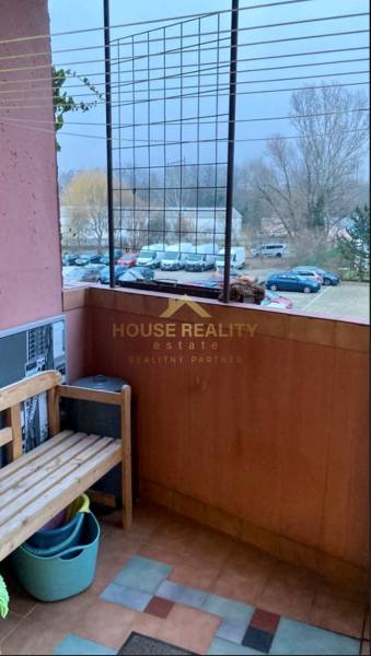 Balkon s dřevěnou lavičkou, výhled na zaparkovaná auta, ulice Jána Poničana, Bratislava - Devínska Nová Ves.