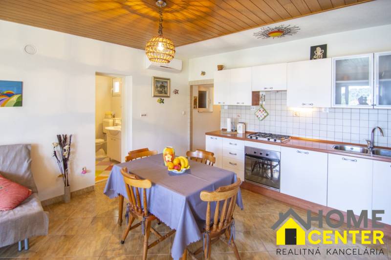 Kuchyně v rekreačním apartmánu s podlahou s dřevěným dekorem a jídelním koutem.