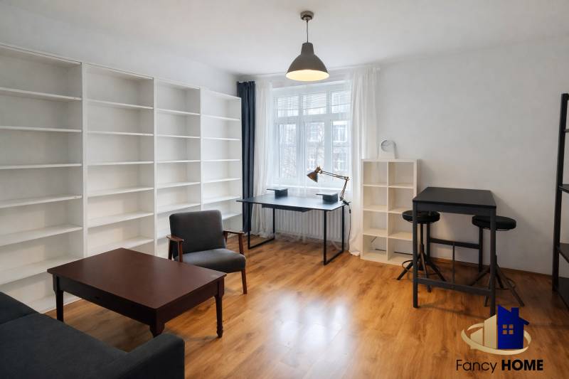 Interiér 2-pokojového bytu s podlahou s dřevěným dekorem, velkými policemi a moderním nábytkem.