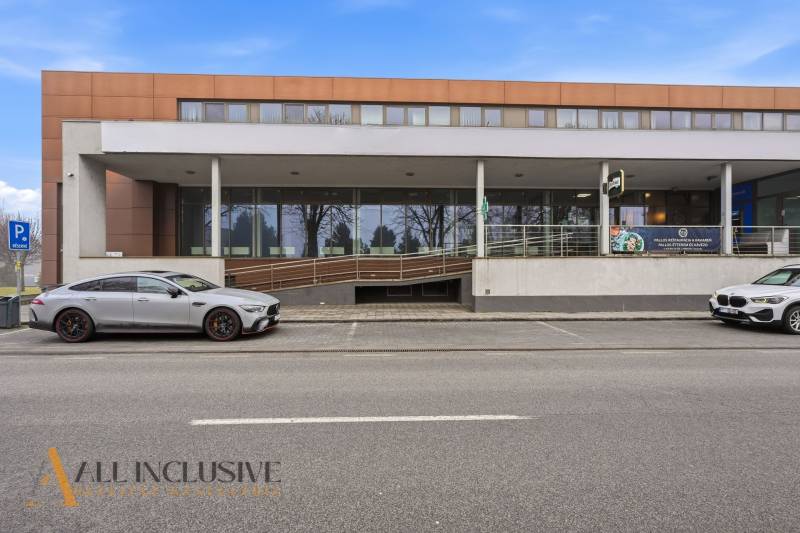 Obchodní prostory v Topoľnících s moderní budovou a parkováním před vchodem.