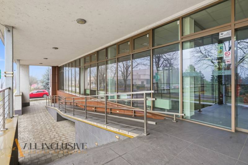 Vstupní prostory obchodních prostor v Topoľníkoch s rampou a prosklenou fasádou.