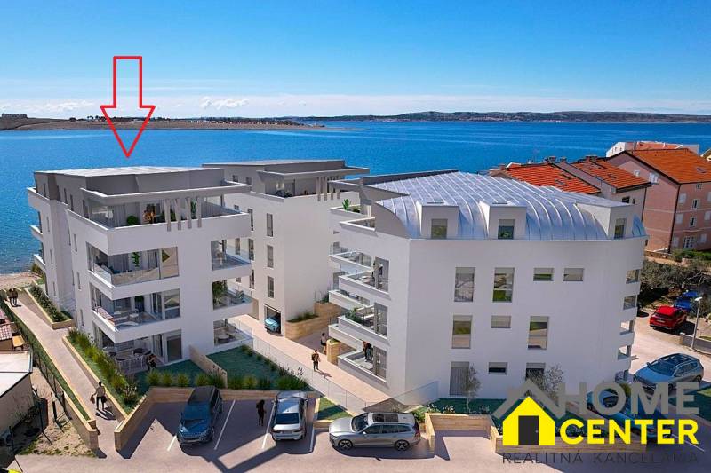 Výhled na mořskou zátoku s Rekreačním apartmánem ve městě Pag, moderní architektura u pobřeží.