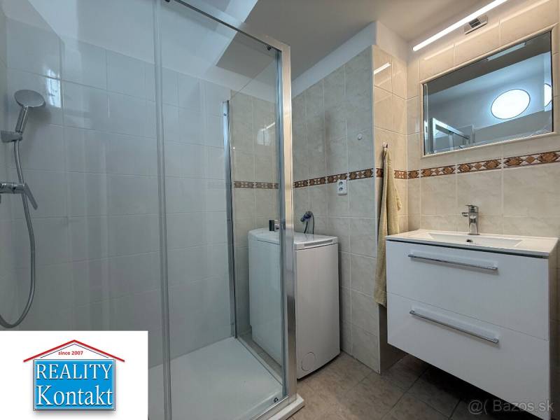 Koupelna v 2-pokojovém bytě s umyvadlem, sprchovým koutem a pračkou.
