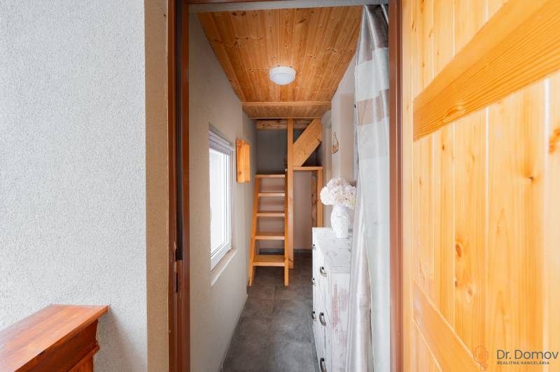 Světlá chodba v chatě s dřevěnými schody a dekorativními prvky.