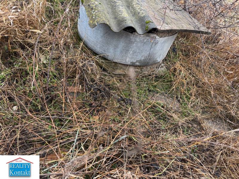 Zarostlý terén s kovovým poklopem v Dubníku na ulici Dubník vhodný pro pozemky - bydlení.