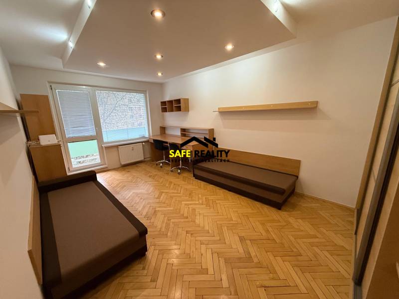 Obývací pokoj v 3-pokojovém bytě s podlahou s dřevěným dekorem a pracovním stolem.